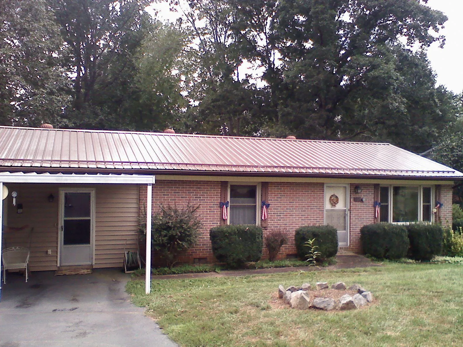 Bronze metal roof and carport on a brick ranch home — Roof Repair work by our crew in Kremlin